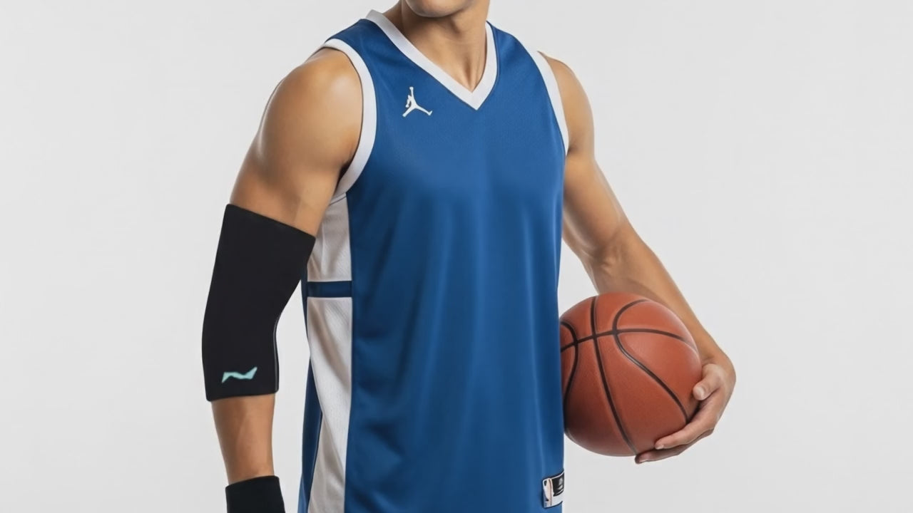 Sportler in blauem Basketballtrikot hält einen Ball und trägt eine schwarze neolevee Ellenbogenbandage am rechten Arm.